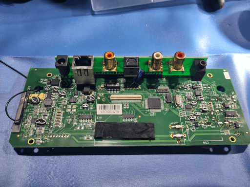 A wide shot of the motherboard, with all the tops of the remaining caps cut off.