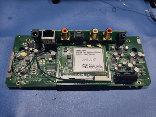 Top-Down photo of the motherboard with the two additional cards installed back and the wifi antennas connected. It mostly looks as before, except the hot glue on two components and the different color on some of the caps. The caps are also a bit more wonky than they where from the factory.