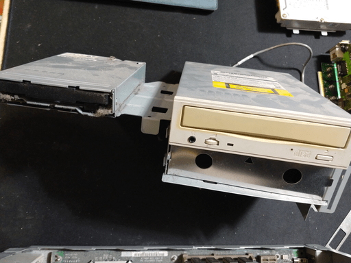 A big metal bracket with a 3,5 inch floppy drive and a 5 1/4 inch CD drive mounted to it. Below the CD drive is an empty space for a hard drive.