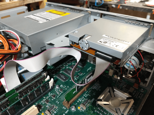 The back side of a floppy drive with one single cable coming out.