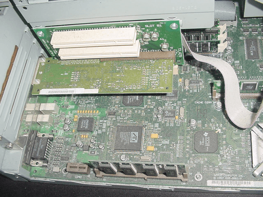 A photo from the inside of a very dusty computer showing part of the motherboard and an expansion card.