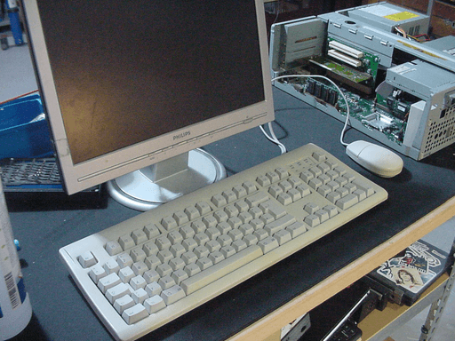 A ADB mouse and keyboard sitting infront of a monitor next to the computer