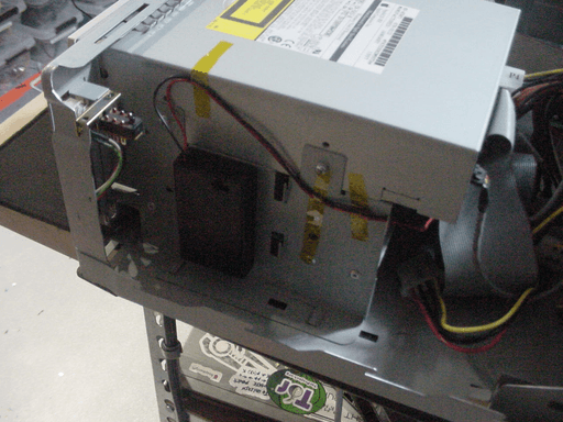 A battery holder with cables coming out from the top taped inside a computer.