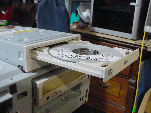 The CD drive ontop of the other one with its drive tray out.