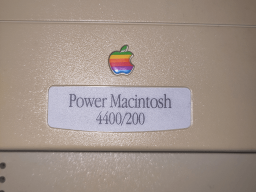 Close-up photo of a badge that says 'Power Macintsh 4400/200' with the rainbow apple logo above.