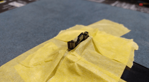 The same photo as before, but now everything except the part above the plastic piece is covered in yellow painters tape.