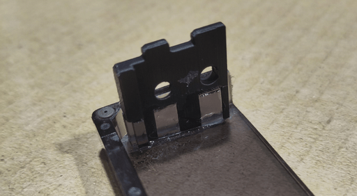 A photo of the replacement part being glued in place from another angle.