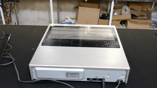 A photo of the record player looking down on it from the back. The scratches on the plastic window that covers the front half of the device are very visible.