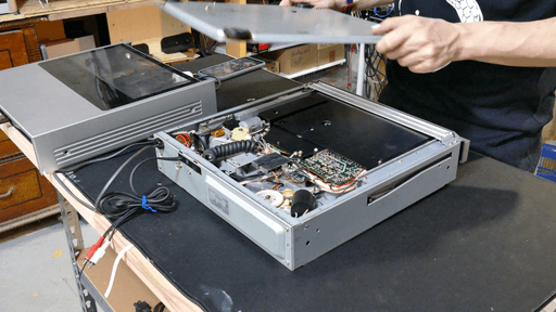 A photo of me lifting away the bottom panel of the record player.