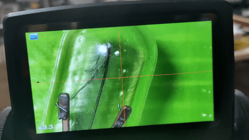 A photo of the screen of my digital microscope. On it is a zoomed-in view of a burnt out miniature light bulb.