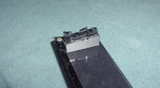 A photo of the flap with a black plastic piece surrounding the bottom part of the broken off bit.
