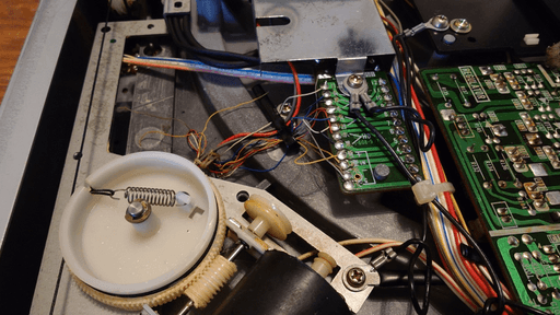 Another photo of the inside of the record player showing a motor and some gears clearly missing a belt between them.